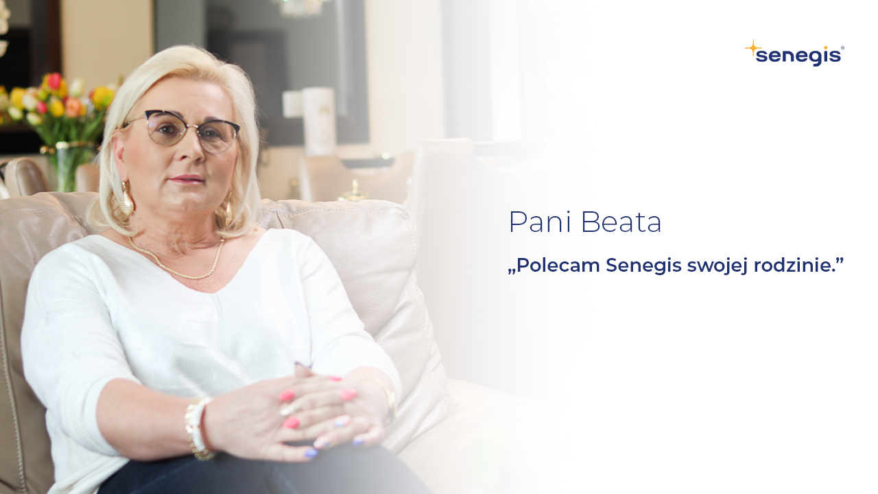 Kobieta w okularach i białym swetrze siedzi na jasnej sofie w nowoczesnym, eleganckim wnętrzu. Po prawej stronie widnieje tekst: ‘Pani Beata – Polecam Senegis swojej rodzinie.’ W prawym górnym rogu znajduje się logo firmy Senegis.