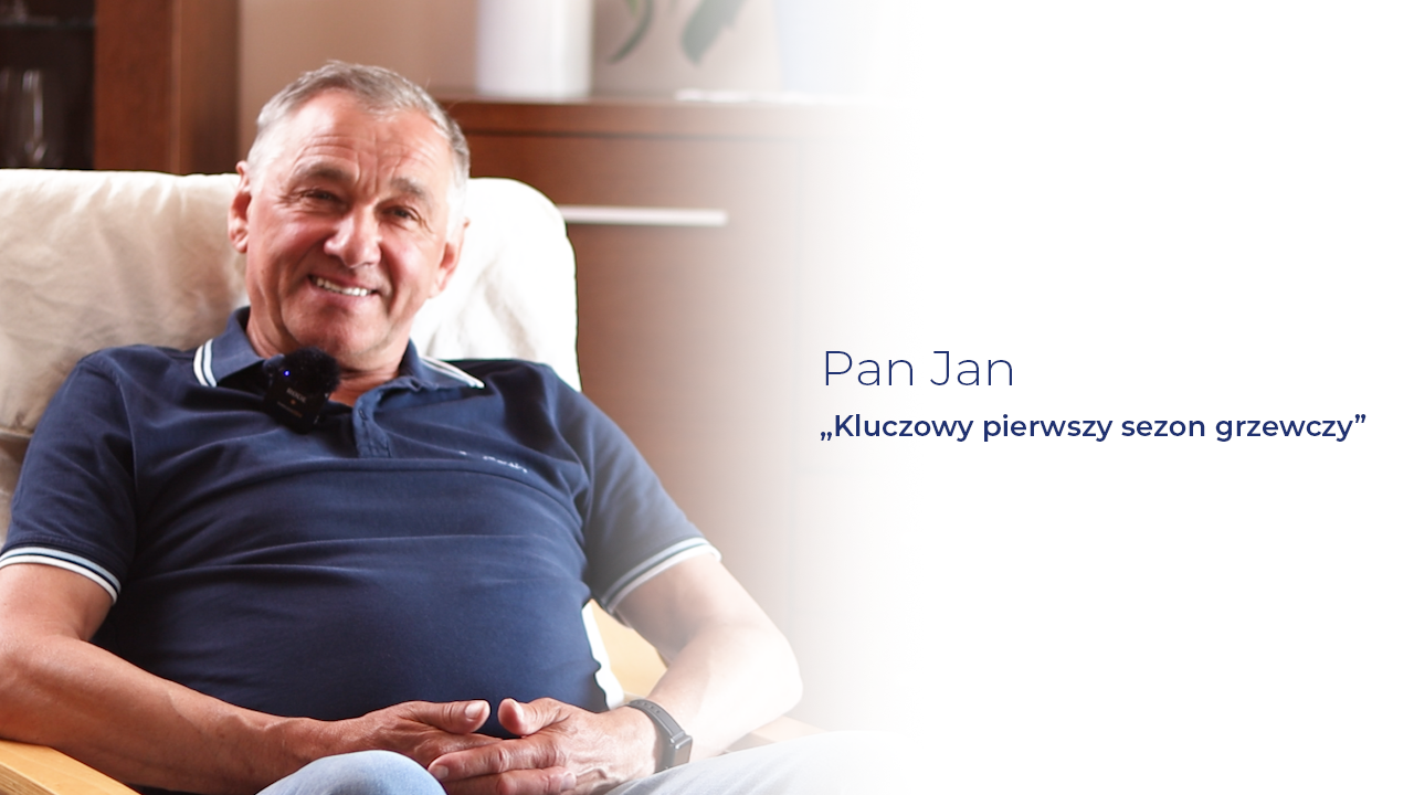 Uśmiechnięty starszy mężczyzna w granatowej koszulce polo siedzi wygodnie na fotelu. Po jego prawej stronie widnieje tekst: ‘Pan Jan – Kluczowy pierwszy sezon grzewczy’. Całość utrzymana w jasnej, domowej scenerii, z logo Senegis w prawym górnym rogu.